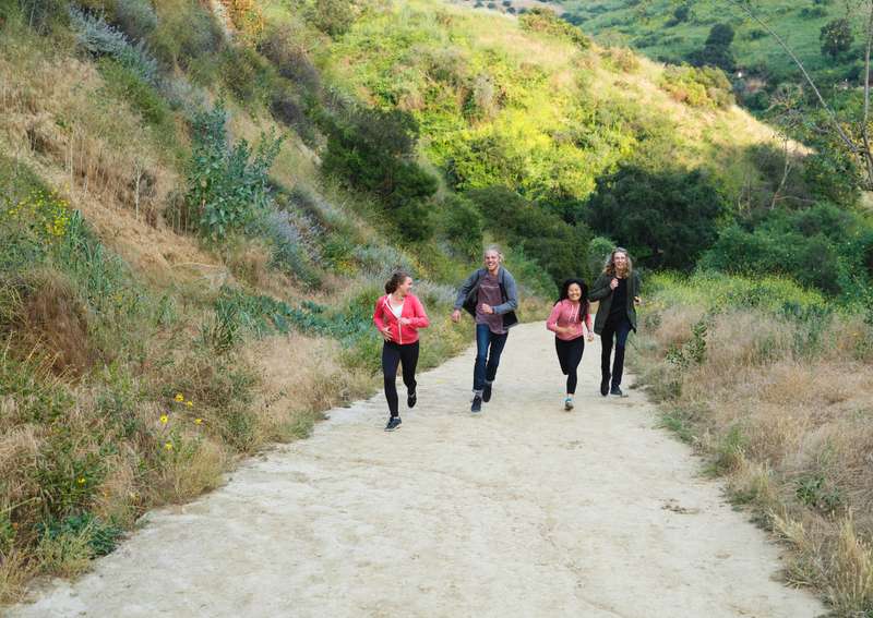 4 students running up a hiking trail